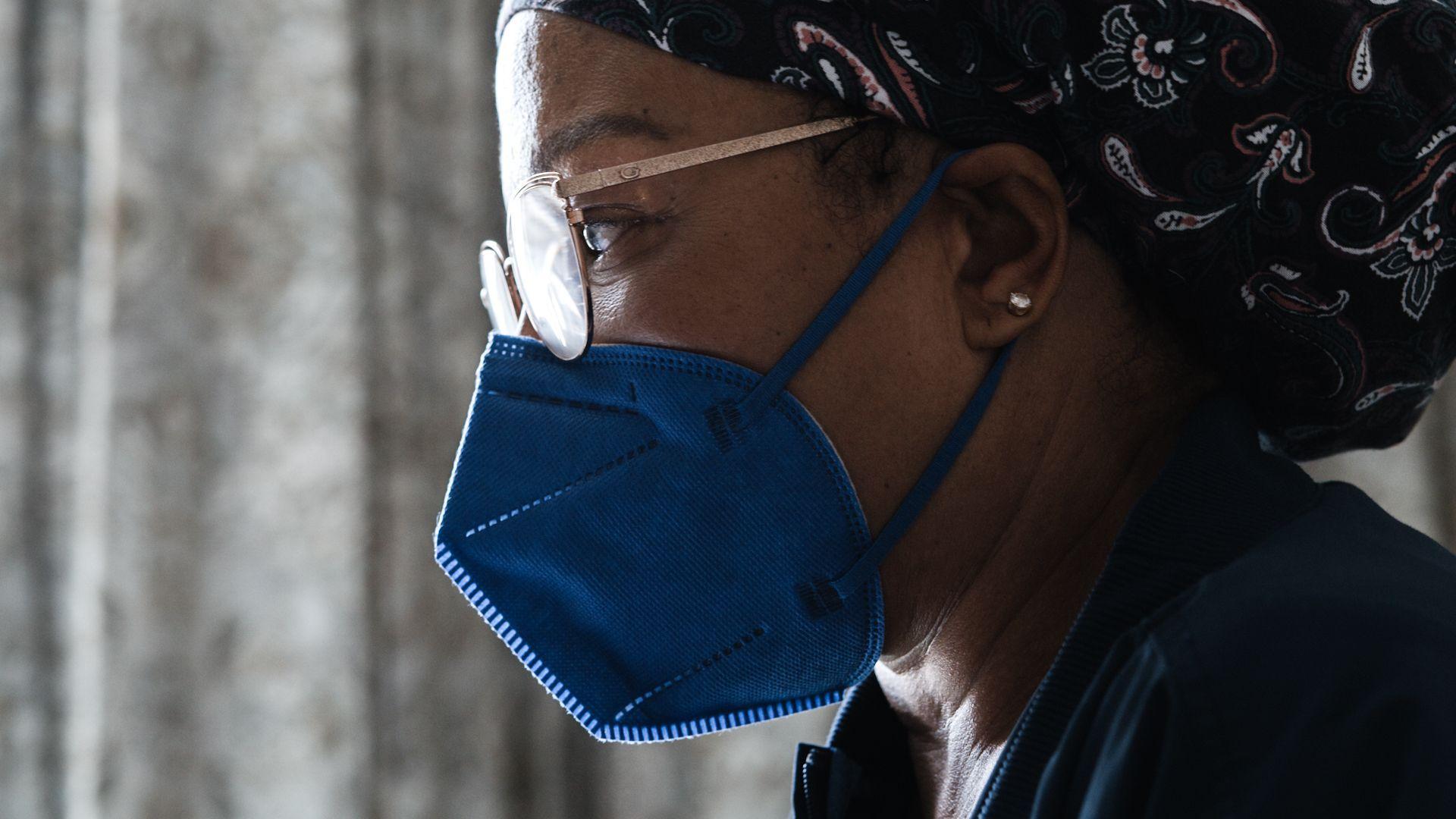 Female nurse in glasses wearing a blue mask